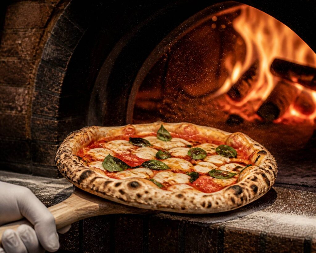 Pizza napolitaine sortant d'un four à bois avec croûte léopardée